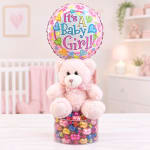 Pink teddy bear with a baby girl balloon and candy-filled base