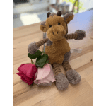 Plush giraffe with two roses on a wooden table