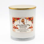 White scented candle in a glass jar with a gold lid