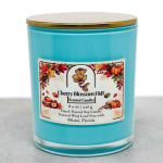 Blue glass candle jar with a gold lid and autumn label
