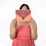 Person holding a boxed chocolate gift set in pink and peach packaging