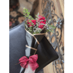 Bouquet of red roses wrapped in black paper with a pink bow