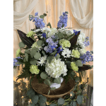 Large bouquet of white, blue, and green flowers in a white vase