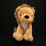 Plush lion toy on a black background