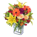 Mixed bouquet of lilies, roses, and gerbera daisies in a clear glass vase