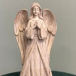Wooden angel figurine with folded hands and large wings