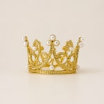Gold crown with pearl accents on a plain background