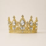 Gold jeweled crown with clear rhinestones on a plain background
