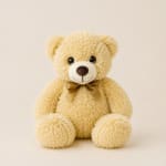 Plush teddy bear with a ribbon bow on a plain background