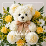 Teddy bear made of white flowers with yellow roses and a bow