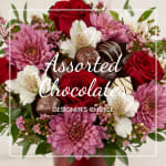 Bouquet of red roses, pink flowers, and assorted chocolates