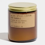 Amber jar candle with a gold lid and spiced pumpkin label