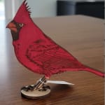 Red cardinal figurine on a small wooden base