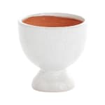 White ceramic pedestal planter with terracotta-colored soil