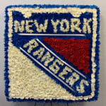 Floral tribute board with blue, white, and red flowers spelling New York Rangers