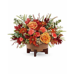 Autumn floral arrangement with orange roses and red blooms in a low container
