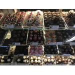 Assorted chocolate truffles and dipped candies arranged in a display case