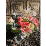 Bouquet of pink and cream roses with white orchids in a white vase