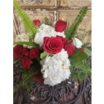 Red roses and white hydrangeas arranged with fern fronds