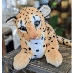 Plush spotted big cat toy on a wooden surface