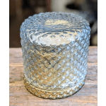 Textured glass candle holder on a wooden surface