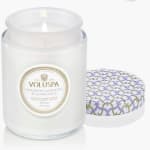 White scented candle in a glass jar with a patterned lid