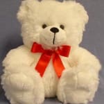 White teddy bear with a red ribbon bow