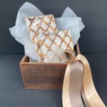 Gift basket with two wrapped boxes in a wooden crate and satin ribbon