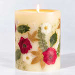 Floral-decorated pillar candle with a lit flame