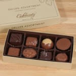 Box of assorted gourmet chocolates in a beige gift box