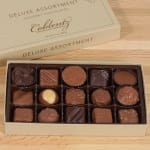Box of assorted gourmet chocolates on a wooden surface