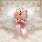 Heart-shaped lace pillow with pink roses and a satin ribbon