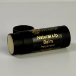 Black lip balm tube labeled Peppermint on a white surface