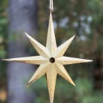 Hanging eight-pointed star ornament in a light wood finish