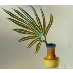 Decorative palm frond in a multicolored ceramic vase