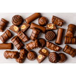 Assorted chocolate candies and nut-filled chocolates on a light surface