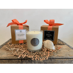 Two boxed candles with orange ribbons and a glass candle with a shell accent