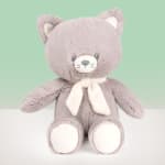 Gray plush teddy bear with a white scarf on a plain background