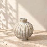 Textured round ceramic vase on a stone surface