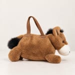 Plush horse-shaped gift bag with a handle on a plain background