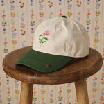 Embroidered baseball cap with a green brim and floral pattern
