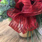 Potted evergreen arrangement with a large red ribbon bow