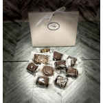 Box of assorted chocolates with a ribbon-tied gift bag