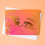 Pink and orange congratulations card with gold monkeys and palm leaves