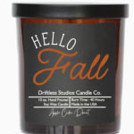 A jar candle labeled Hello Fall with a black lid.