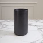 Black cylindrical vase on a marble surface