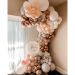 Clustered white, blush, and rose-gold balloons arranged in a corner