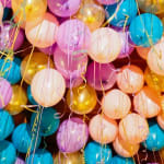 Cluster of colorful hanging paper lanterns with gold tassels