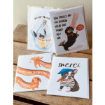 Four dog-themed greeting cards stacked on a wooden surface