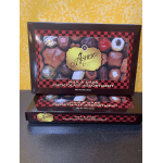 Two boxes of assorted milk and dark chocolates stacked on a counter